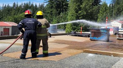 Participants in Indigenous Youth Career Camp at JIBC learn to use a fire hose at the Maple Ridge campus.