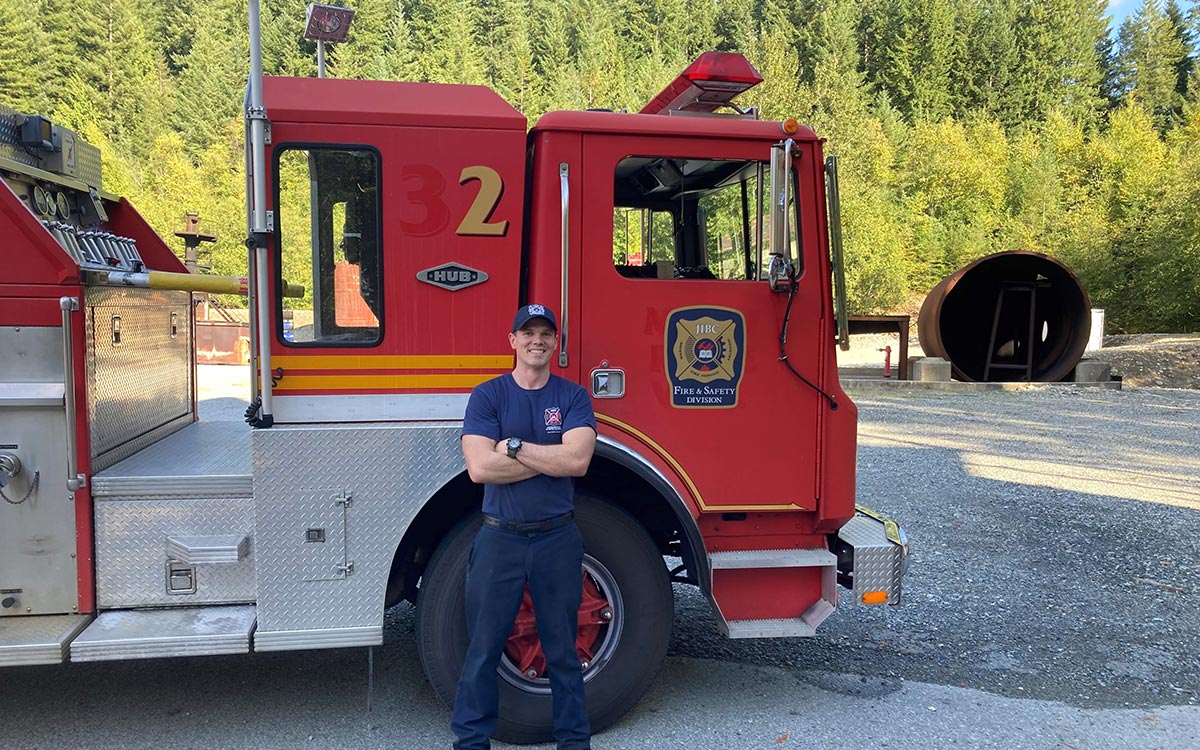 FFTC grad Jesse Fryer in front of fire truck at JIBC's Maple Ridge campus.