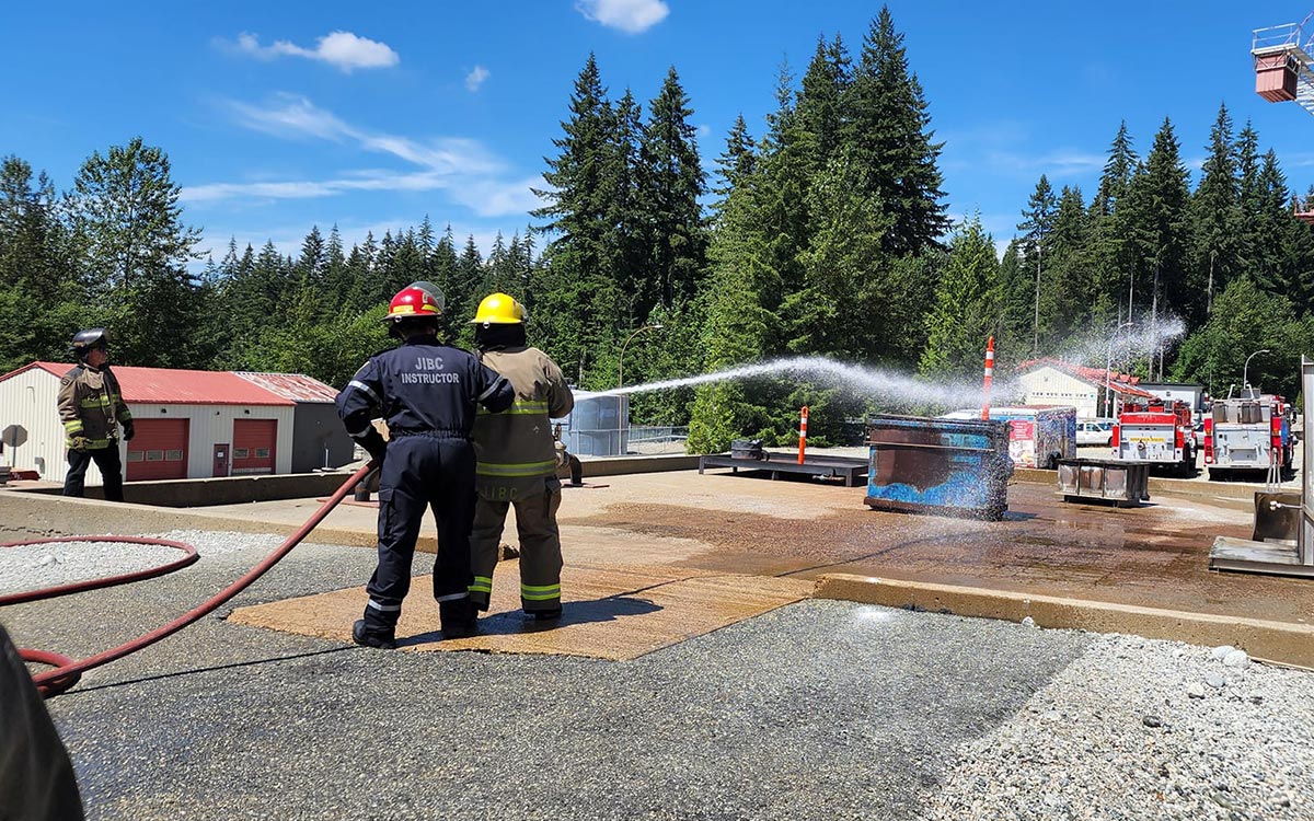 Participants of the JIBC Indigenous Youth Career Camp learn the basics of using a fire hose at the Maple Ridge campus.