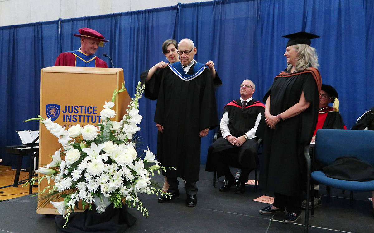 Judge Thomas Gove is hooded by JIBC Board Vice-Chair Maria Preovolos as he is conferred an honorary degree at the 2022 Spring Convocation ceremony.