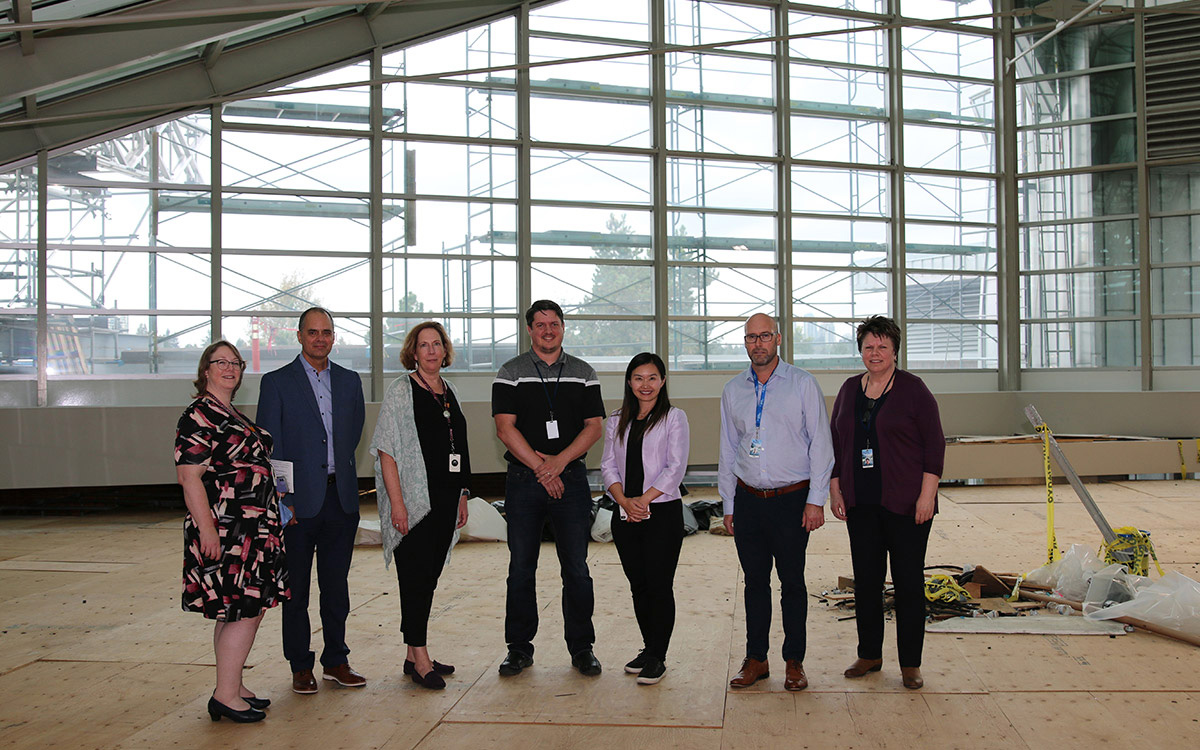 Minister Anne Kang, third from right, gets a closer look at the ministry-funded glass roof replacement project at New Westminster campus.