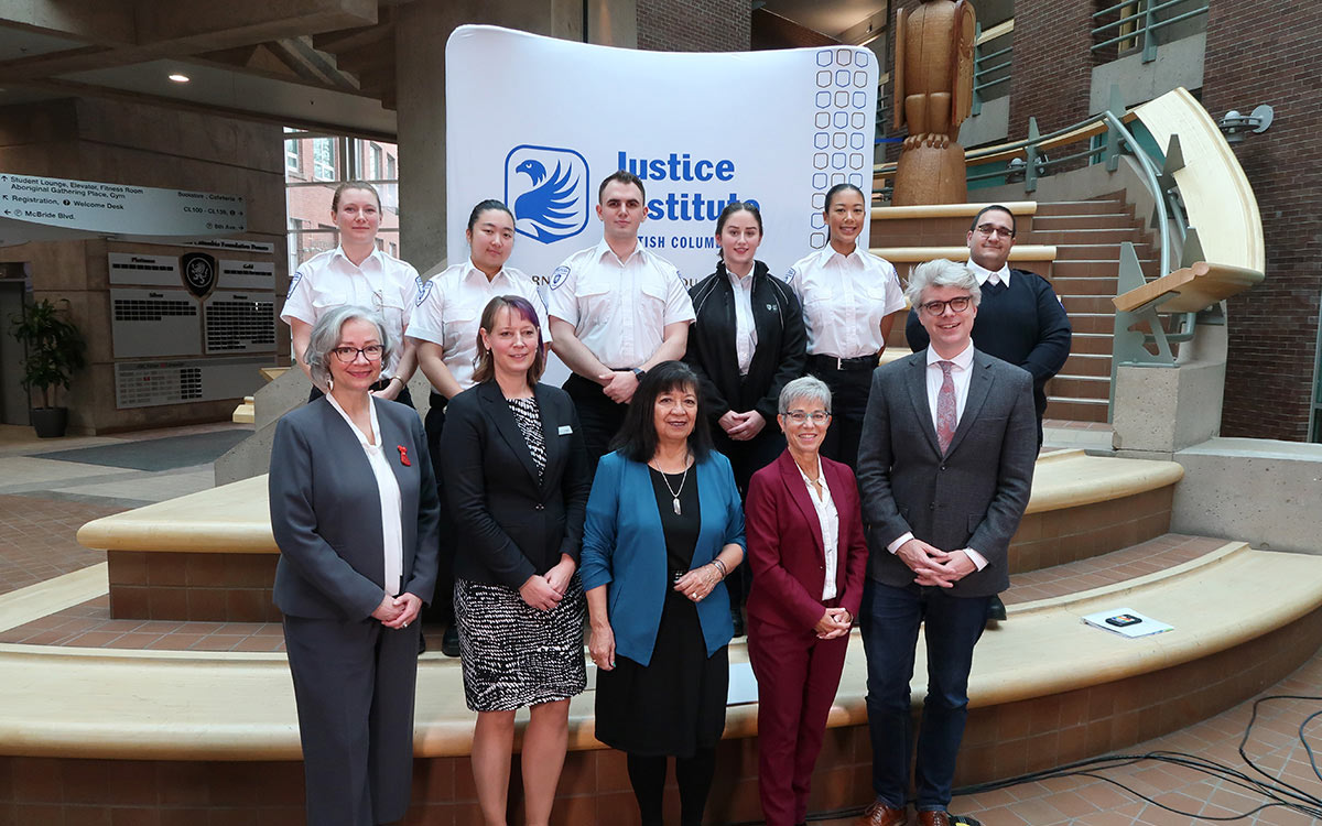 Dignitaries and paramedic students pose in front of JIBC display banner.