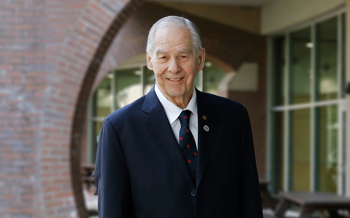Man with grey hair wearing dark suit and tie.