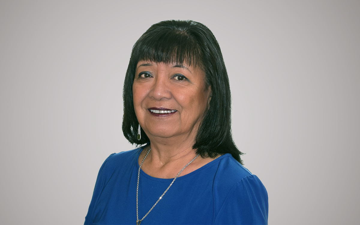 Woman with dark hair wearing blue top