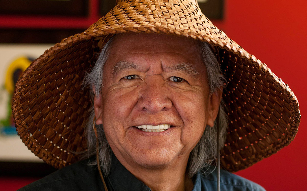 Man wearing traditional Indigenous woven hat.