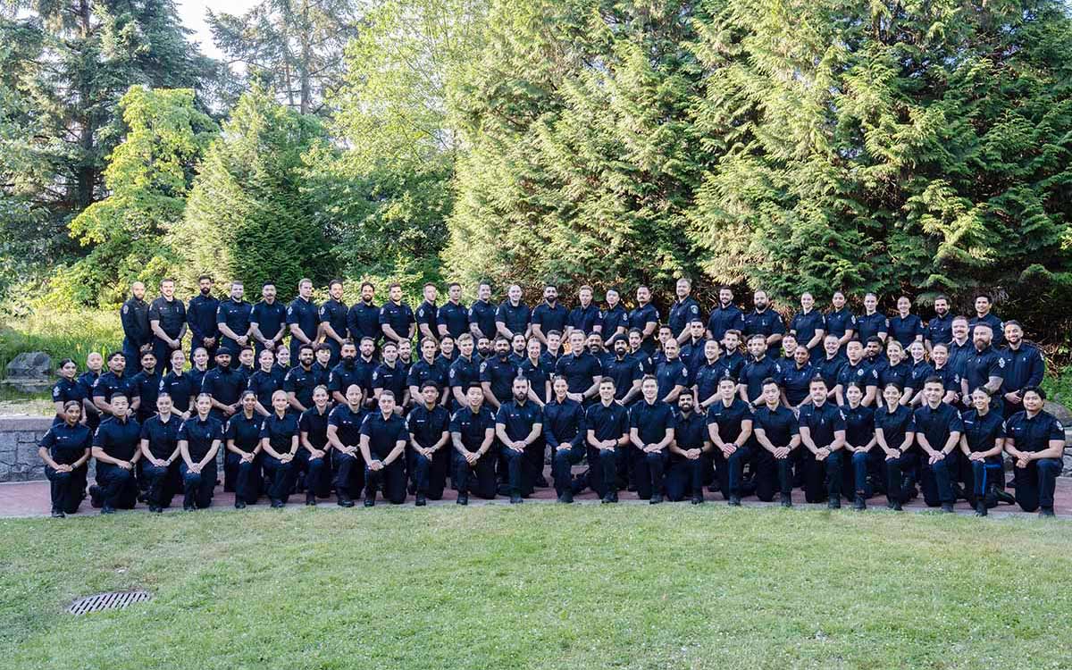 Police Academy class photo taken outdoors of 96 recruits in uniform