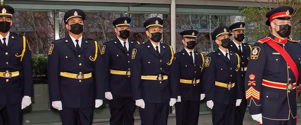 Class of sheriff recruits stand at attention during graduation ceremony at Vancouver Law Courts.