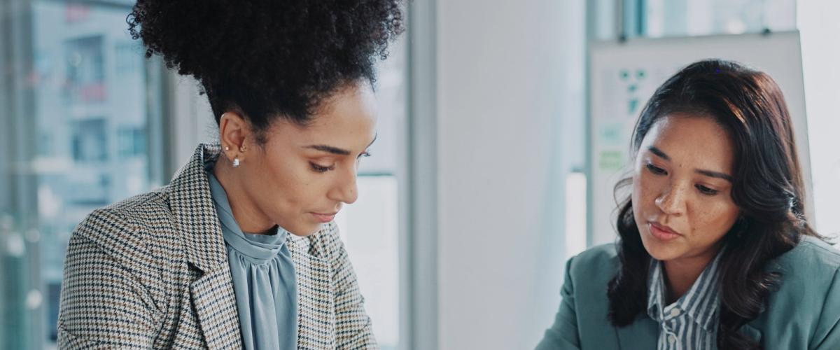 2 women in a meeting room discussing