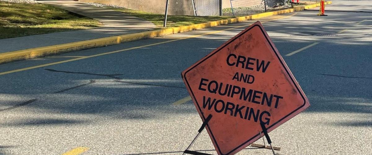 Construction sign reading crew and equipment working