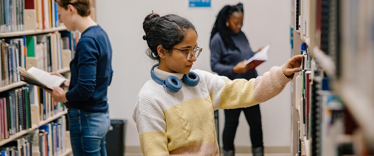 student looking at books