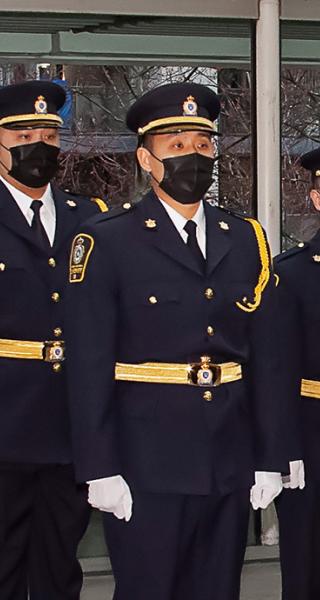 Class of sheriff recruits stand at attention during graduation ceremony at Vancouver Law Courts.