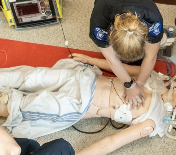 Overhead shot of Advanced Care Paramedic students practising CPR on a mannikin.