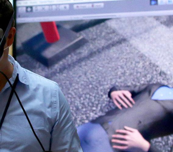 Man wearing virtual reality googles against backdrop of virtual reality simulation program.