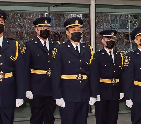 Class of sheriff recruits stand at attention during graduation ceremony at Vancouver Law Courts.