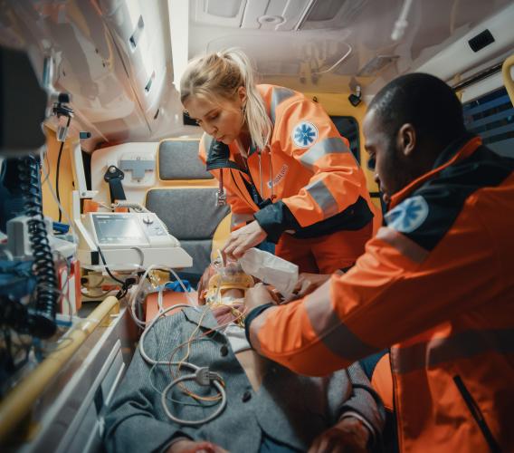 Two paramedics working on patient in back of ambulance.
