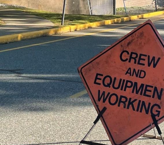Construction sign reading crew and equipment working