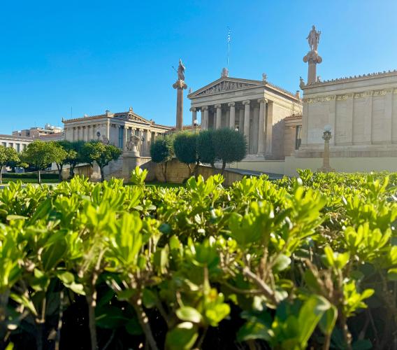 Old Greek building with pillars in the distance.