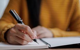 women writing on a white notepad