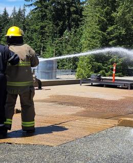 Participants in Indigenous Youth Career Camp at JIBC learn to use a fire hose at the Maple Ridge campus.