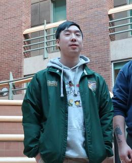 Two male students in atrium at JIBC's New Westminster campus, with Welcome Post in the background.