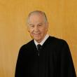 Head and shoulders shot of man in black graduation robe.