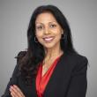 Woman wearing black blazer and red top.