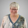 Woman with grey hair wearing glasses.