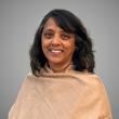 Woman with dark hair wearing beige shawl.