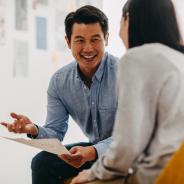 Two people engaged in a discussion, with one holding a piece of paper