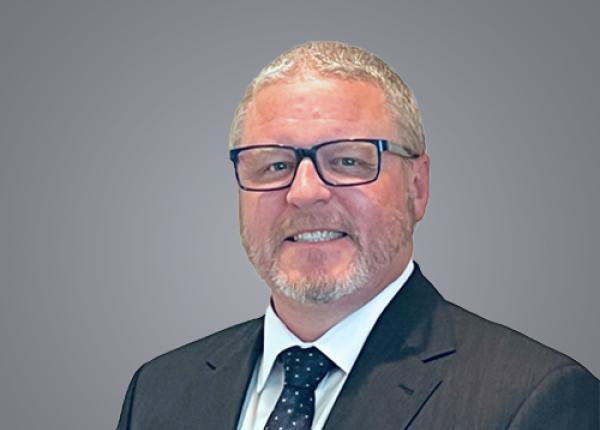 Head and shoulders image of man wearing classes and suit and tie.