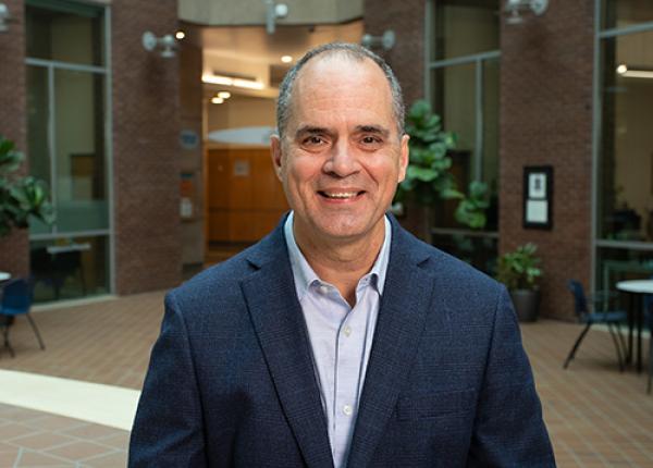 Man wearing dark blue jacket and grey shirt.