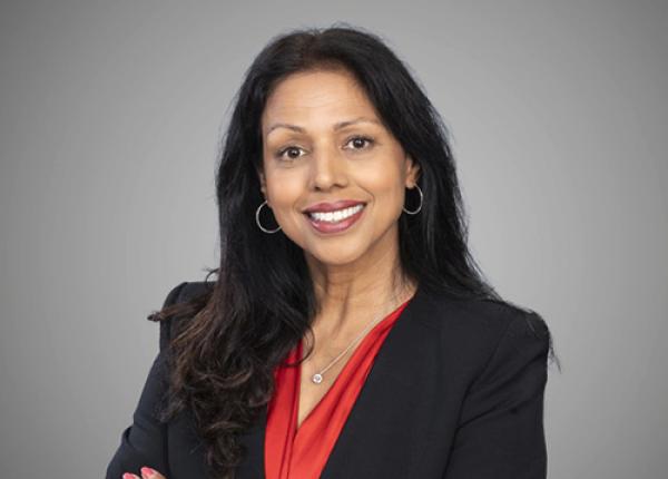 Woman wearing black blazer and red top.